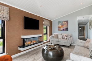 Cozy living space with a fireplace, flat-screen TV, and comfortable seating area.