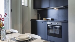 Una cucina moderna con mobili scuri, una cappa aspirante in acciaio inossidabile e un forno integrato.