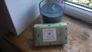 A candle and a hand soap box on a windowsill. - Driftwood Loft (Downpatrick)