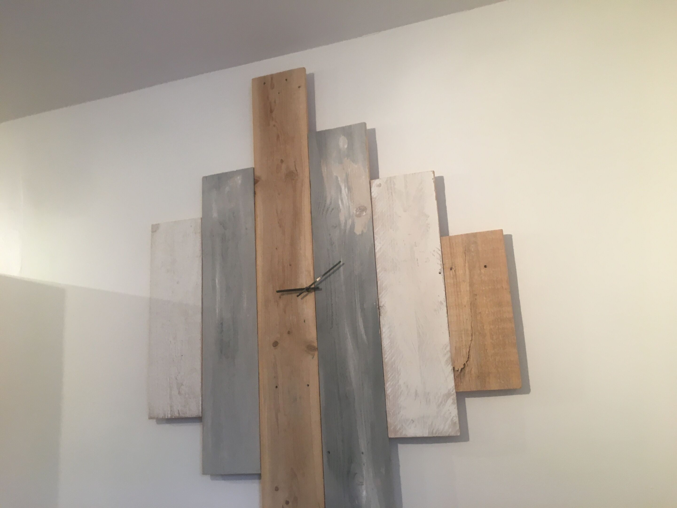 A wall with variously sized and colored wooden panels.
