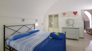 Un dormitorio con cama, cómoda, espejo y armario.