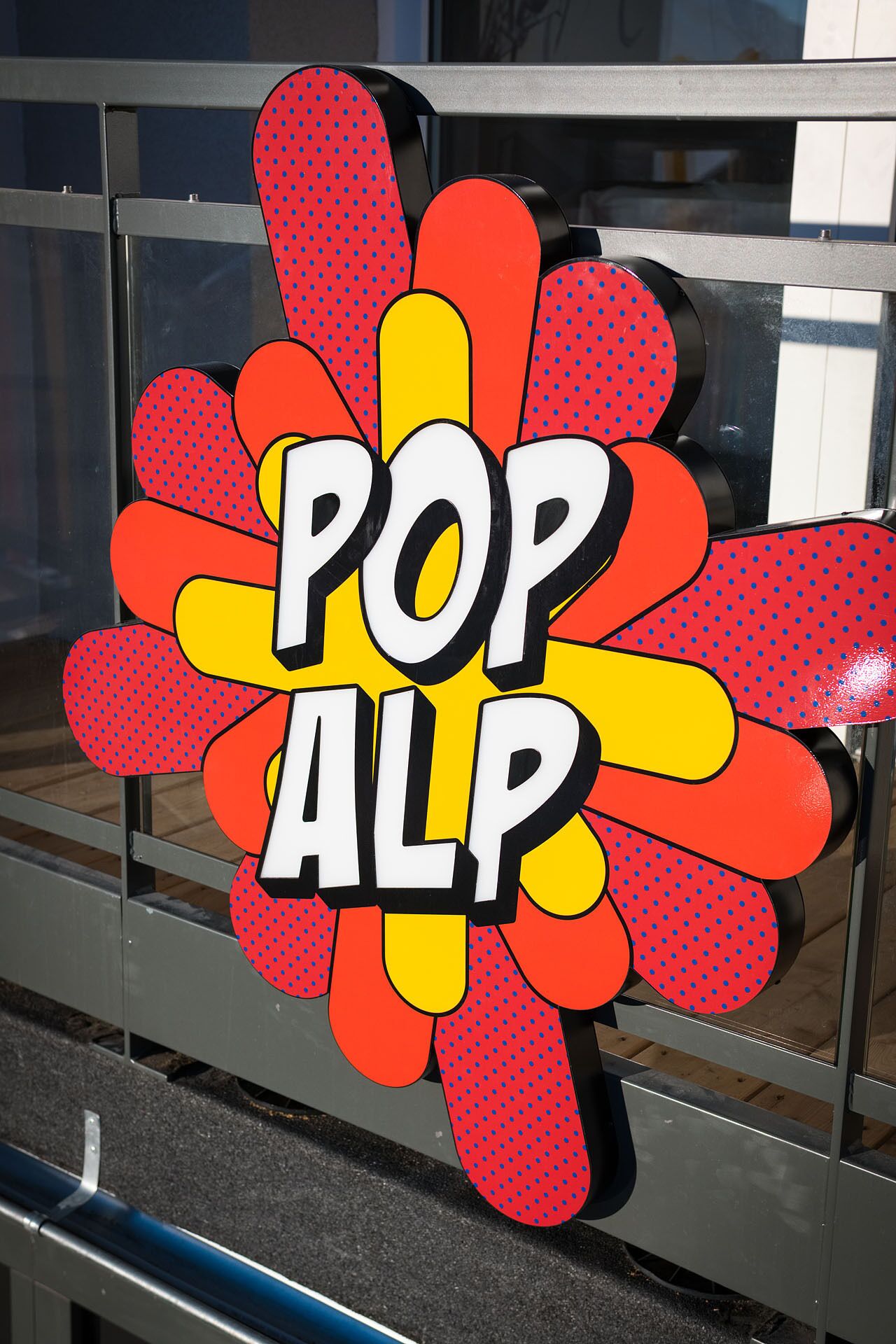 A pop art style sign with the text "POP ALP" on a metal structure.