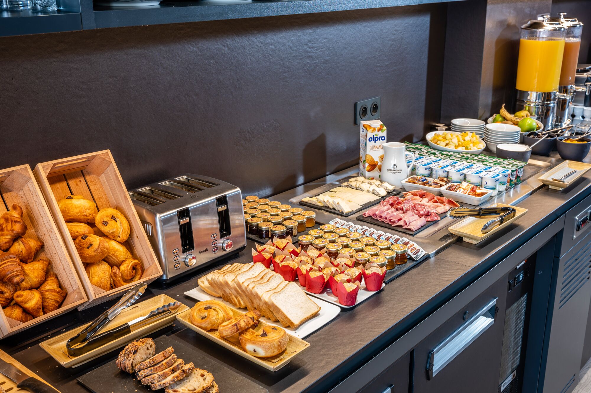 Un bufé con diversas opciones de comida, incluyendo pasteles, carnes y salsas.