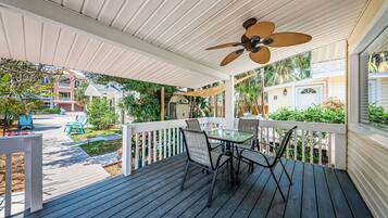 Enjoy a peaceful outdoor space with a deck, table, and chairs, offering a view of the surrounding neighborhood.