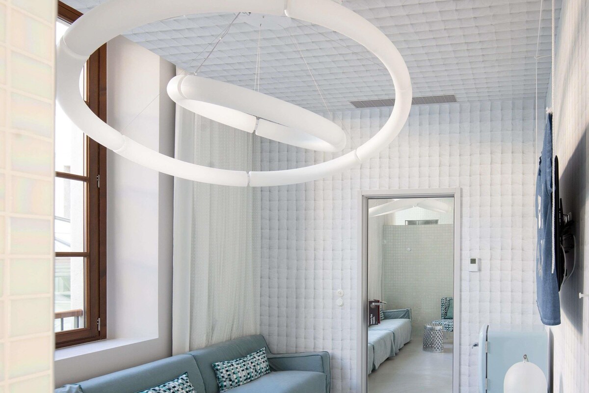 A modern interior with a sofa, a television, and a unique ceiling design.