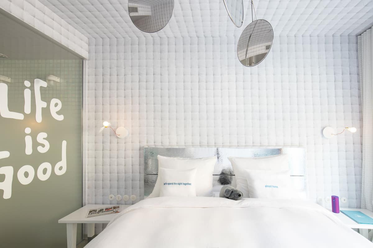 Relax in a serene space with a large bed, bedside table, and stylish lighting.