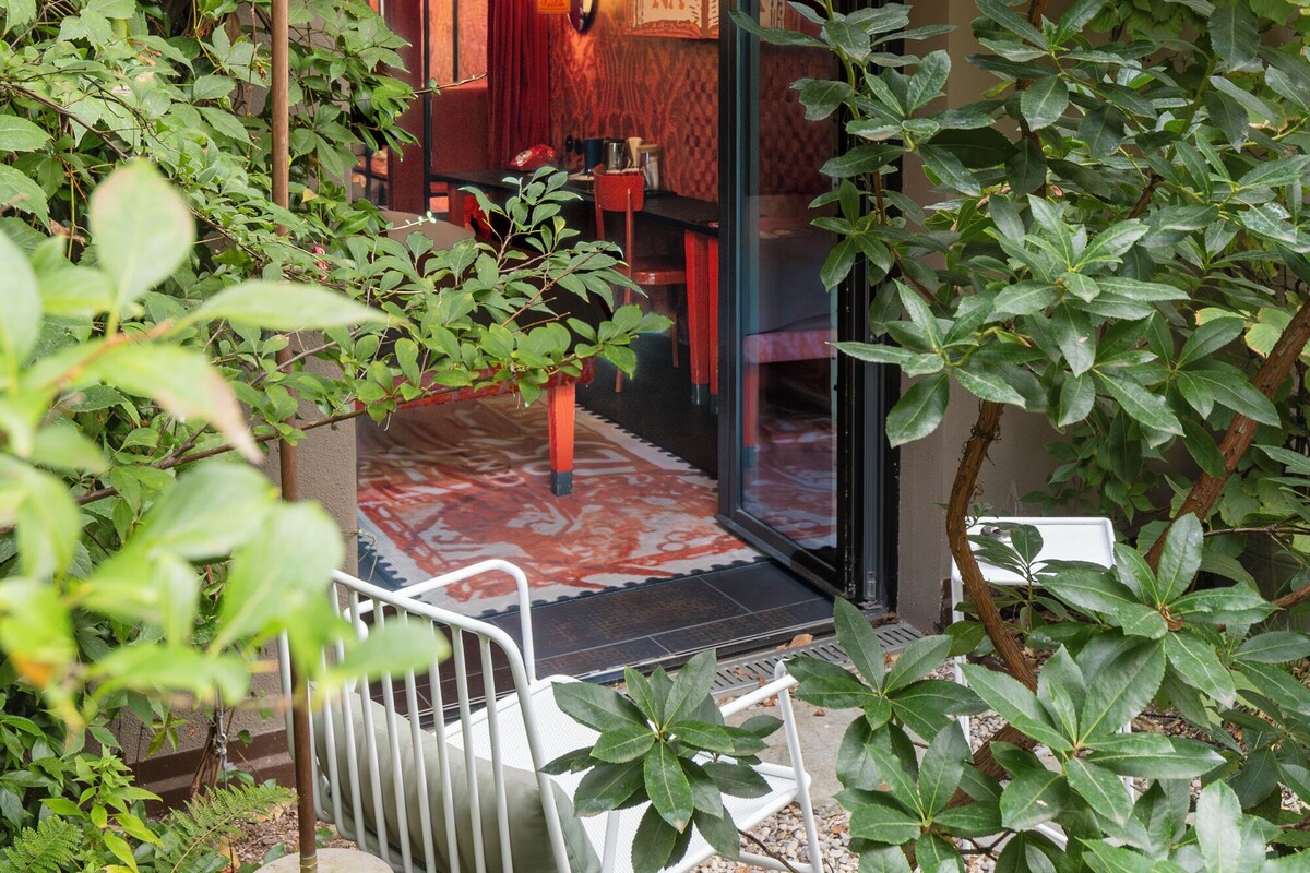 A traditional Japanese-style entrance with a wooden door, a small seating area with a bench, and a decorative hanging light fixture.