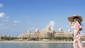 A large resort hotel with multiple domed structures, a beachfront, and palm trees.