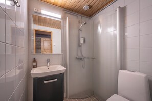 Moderni kylpyhuone, jossa on valkoinen pesuallas, peili ja suihkukaappi.