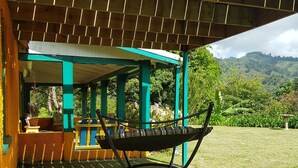 A hammock under a wooden pergola with a view of a lush landscape. - Blue Mountains Jamaican Vacation (St Peters)