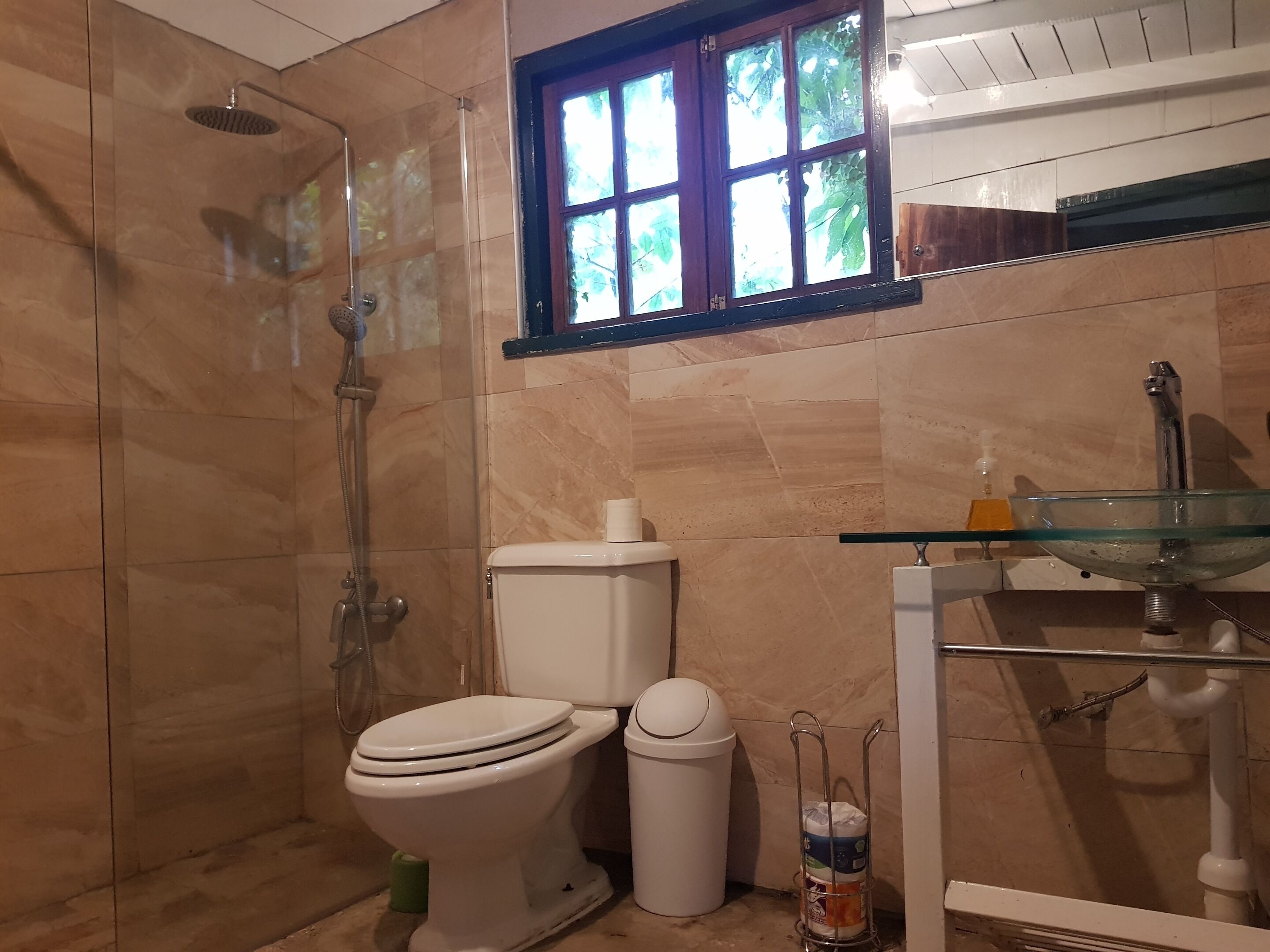Een douche, handdoeken, zeep, toiletpapier