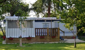 Guests can enjoy a deck with potted plants and a well-manicured lawn.