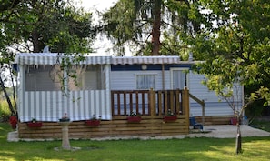 Guests can enjoy a deck with potted plants and a well-manicured lawn.