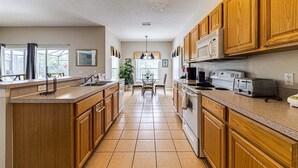 Una cocina con armarios de madera, una isla central, un microondas y una estufa.