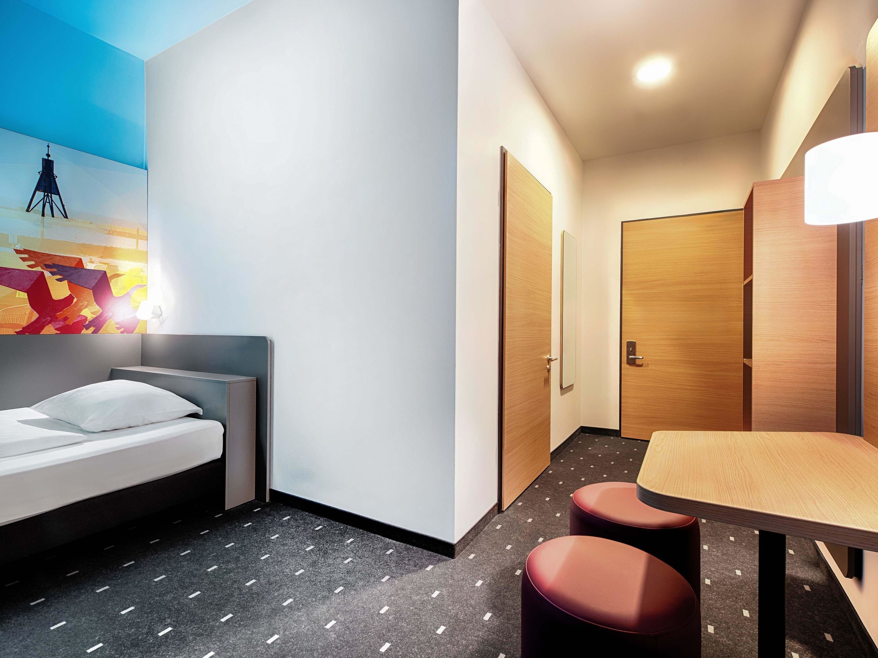 Quarto de hotel com cama, mesa de jantar e um pequeno espaço para sentar.