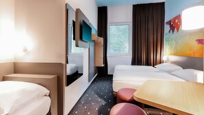 A hotel room with a bed, a desk, a chair, a TV, and a window. - B&B Hotel Cuxhaven (Cuxhaven)