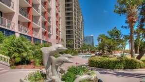 Un hotel moderno con un patio central que presenta una escultura de delfín.