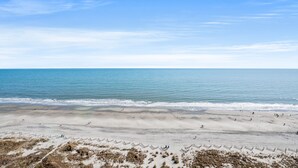 Una playa con cielo despejado y mar tranquilo.