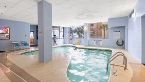 An indoor swimming pool with clear water, two separate lanes, and a lifeguard station.