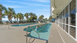 A pool area with multiple swimming lanes, palm trees, and a lifeguard station. - Boardwalk Beach Resort #932 Gorgeous1 Bedroom Oceanfront Condo (Myrtle Beach)