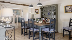 A dining area with a wooden table, dark chairs, and pendant lights. - Cats Abbey Cottage a charming,  Northleach , Gloucestershire (Northleach)