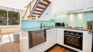 A modern kitchen with white cabinets, a built-in oven, and a coffee maker. - ★ Sunshine Loft With Balcony by ★ Sydney Dreams ★ (Bondi Beach)