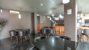 A modern restaurant with a long counter, multiple tables, and chairs. - OYO 172 Gunung Sahari 12 Residence (Jakarta)