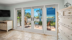 A room with a sliding glass door leading to a balcony with outdoor furniture and a view of the ocean. - Luxury Pool and Rooftop Deck, Walk to Siesta Key Beach and Village! - Casa Siest (Siesta Key)