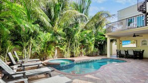 A swimming pool with lounge chairs and a hot tub, surrounded by lush tropical plants. - Luxury Pool and Rooftop Deck, Walk to Siesta Key Beach and Village! - Casa Siest (Siesta Key)