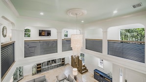 A spacious living area with a fireplace, seating, and a TV mounted on the wall. - Luxury Pool and Rooftop Deck, Walk to Siesta Key Beach and Village! - Casa Siest (Siesta Key)