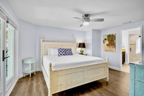 A bedroom with a bed, a ceiling fan, a nightstand, a lamp, and a painting on the wall. - Luxury Pool and Rooftop Deck, Walk to Siesta Key Beach and Village! - Casa Siest (Siesta Key)