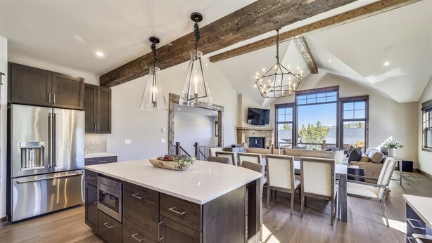 A spacious kitchen with a large island, stainless steel appliances, and a high ceiling with exposed beams. - Cocoa Cabin: New Baldy Mtn Home, Hot Tub & Steam Shower, EV Charger! (Breckenridge)
