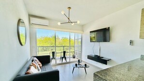 Un salon moderne avec un canapé, une table basse et un téléviseur fixé au mur.
