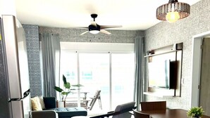 Una cocina moderna con comedor, ventilador de techo y televisor montado en la pared.