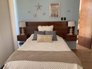 Relax in a serene bedroom with a large bed, two nightstands, and soothing decor.
