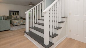 A staircase with white railings and dark steps, leading to a white door.