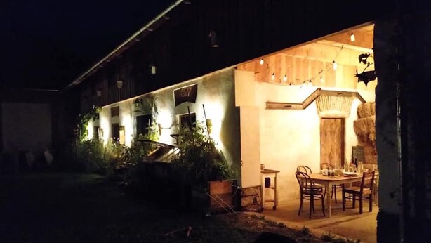 Um edifício com área de jantar iluminada por luzes quentes, com mesa e cadeiras.