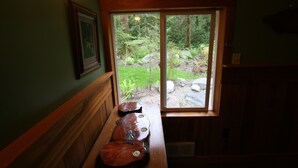 Un banco de madera con vistas a un jardín a través de un ventanal.