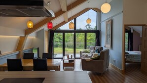 Un loft spacieux avec de hauts plafonds, de grandes fenêtres, un coin repas et un espace salon confortable.