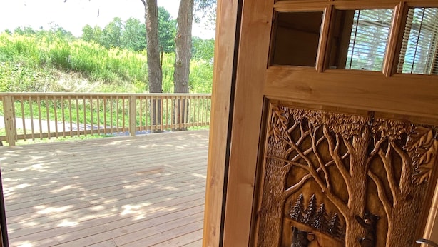 A wooden door with a doormat and a carved tree design. - #1 Cabin~Walk to WISP! Lake access & dock! HOT Tub~Game room~Fire Pit & DOGS OK! (McHenry)