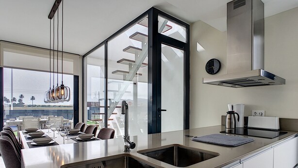 A modern kitchen with a large island, stainless steel appliances, and a view of the outdoors. - Modern villa with private pool (Mar de Cristal)