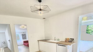 Eine moderne Küche mit weißen Schränken, einer Holz Arbeitsplatte und einer Deckenleuchte.