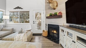A living room with a mounted deer head, a fireplace, a television, and a cozy seating area. - JUST FINISHED RENOVATIONS 2023!!! A lavishly styled ski-in/out winter escape! (Brian Head)