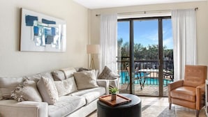 A living room with a sofa, a round ottoman, a chair, and a pool view. - Waterfront Paradise
2.5 miles from Beach
28 ft Boat Slip
Marina View (Fort Walton Beach)