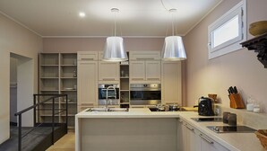 Una cocina moderna con una isla central, armarios empotrados, microondas y cafetera.