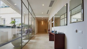 Un pasillo con paredes de vidrio, una barra de madera y vistas al exterior.