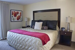 Cozy retreat with a large bed, bedside tables, and a framed picture of flowers.