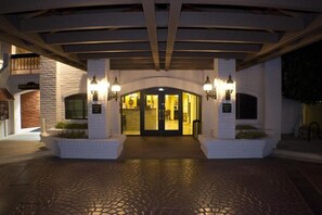 Classic entrance with a central archway, flanked by double doors and wall-mounted light fixtures.