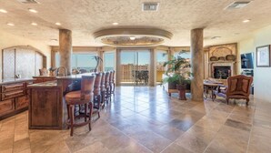 A spacious kitchen with a large island, a dining area with chairs, and a fireplace.