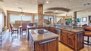 A spacious kitchen with a large island, granite countertops, and wooden cabinetry.
